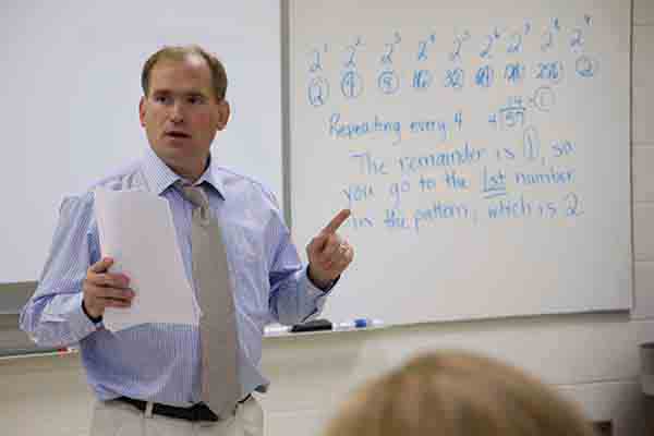 A professor stands in front of his class lecturing on patterns