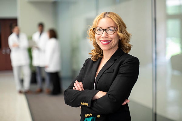 Health administration professional in the foreground with three health professionals in the background.