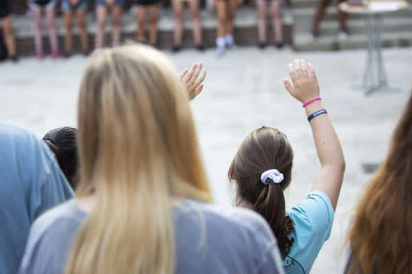 Student singing at outdoor worship