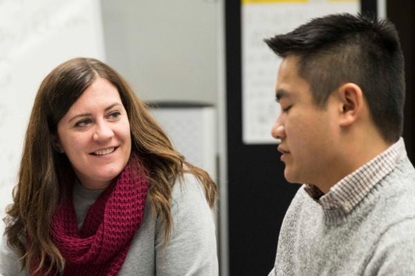 Teacher talking at a table with a student.