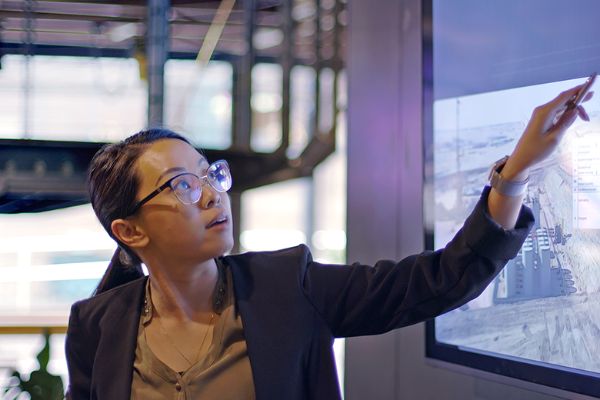 Woman pointing to a screen with data
