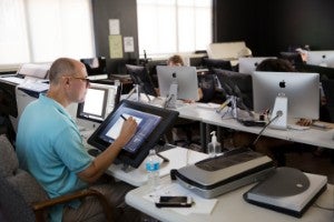 Male faculty sitting in front of computer