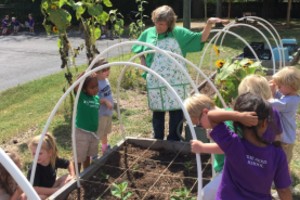 Young students take care of a garden located outside the school building.