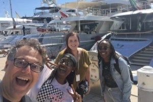 Faculty and students standing on a boat dock in Cannes. 