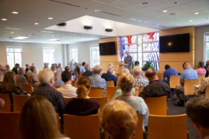 Crowd of people in class with speaker at podium