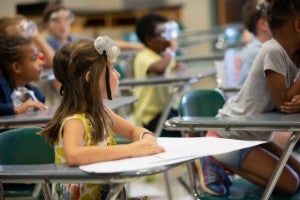 Young girl sitting at desk in classroom