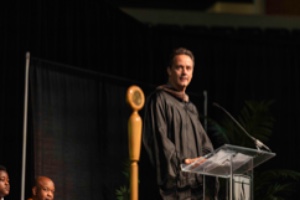 Mike Nawrocki in academic regalia at a podium