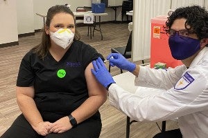 Sarah Uroza gets a Covid vaccine from Justin Kirby