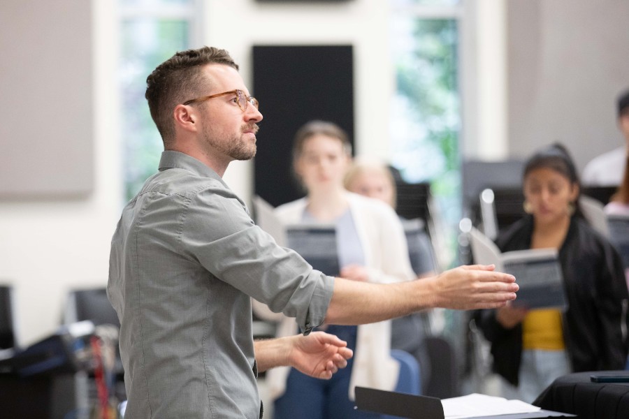 Matt Taylor directing choral students in rehearsal room