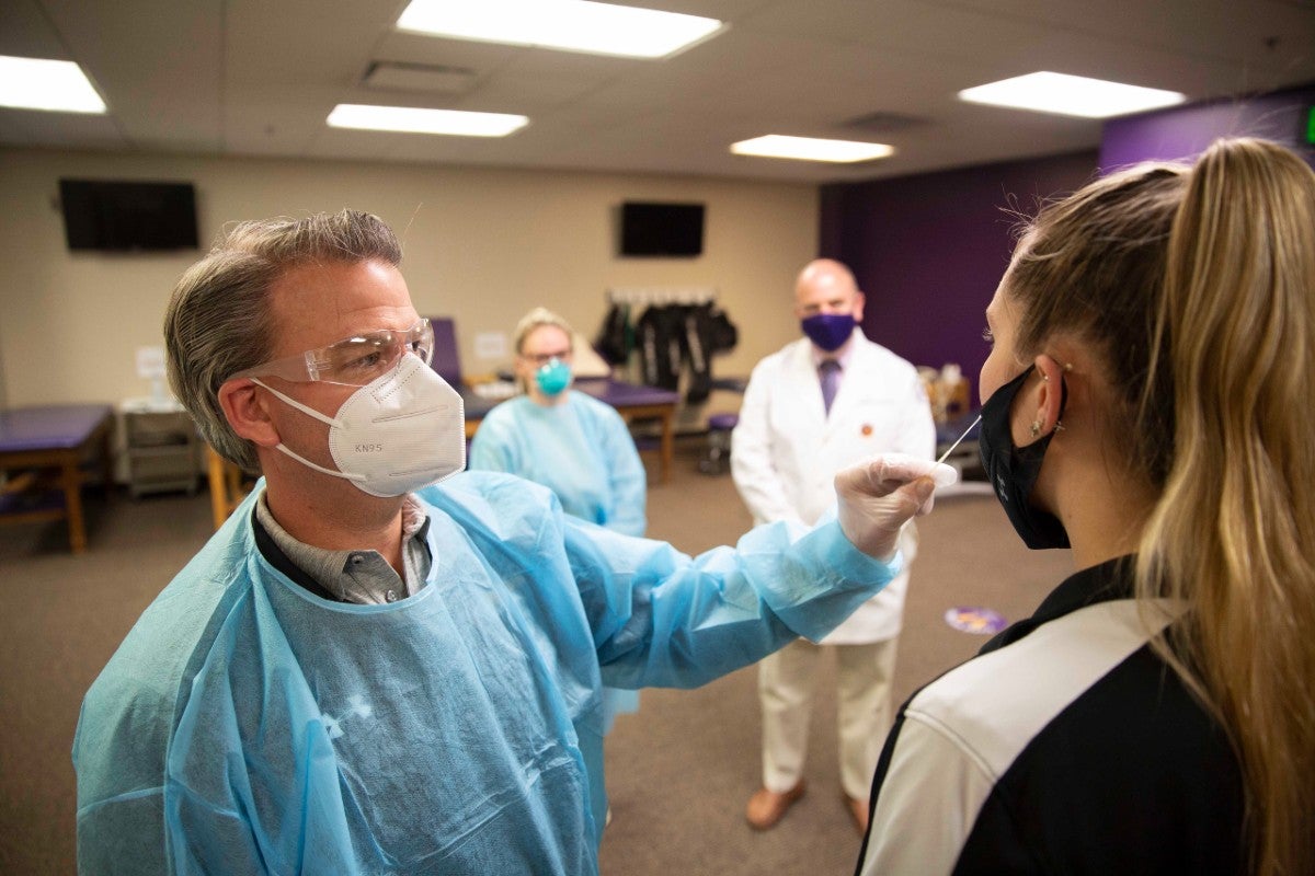 Health care worker giving a Covid test to athlete