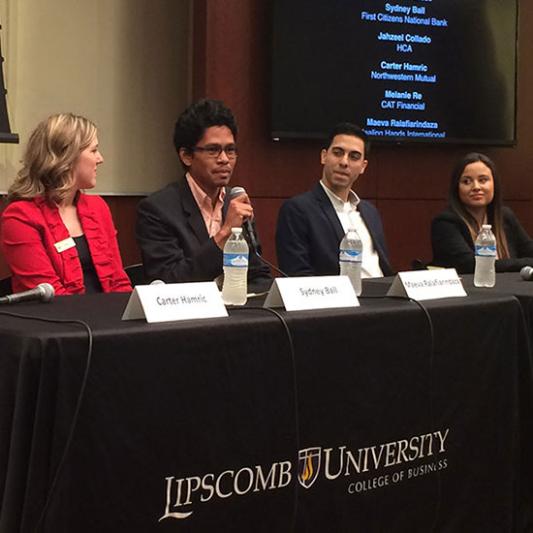 Alumni speaking to a group during an event.