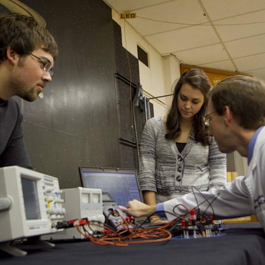 Physics students working with a faculty member.