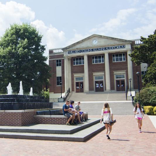 Students walk through Bison Square on a sunny day.