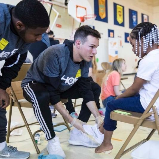 Business students serve children