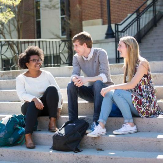 students sitting on the steps outside