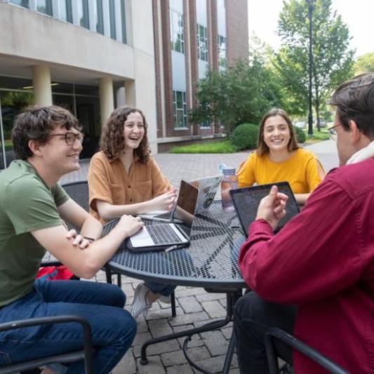 Students talking around a table outdoors at Lipscomb