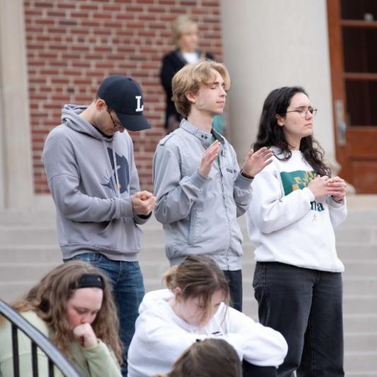 students worshipping outside