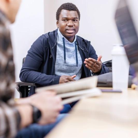 Male student speaking up during a class discussion