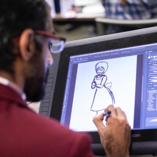 Student sketching out character in animation lab