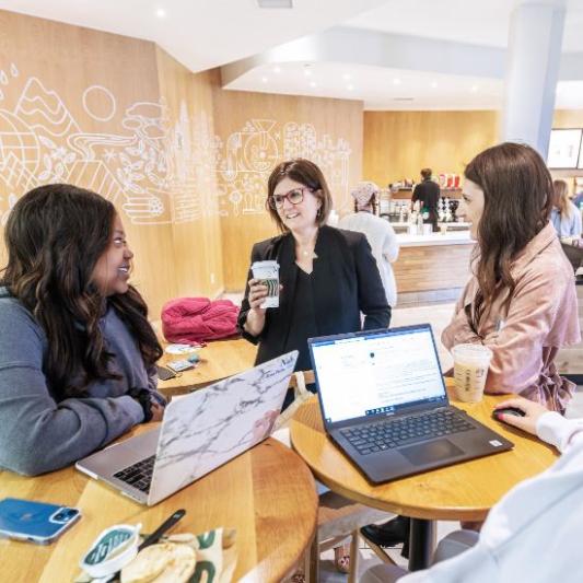 Two students meeting in Starbucks with their professor