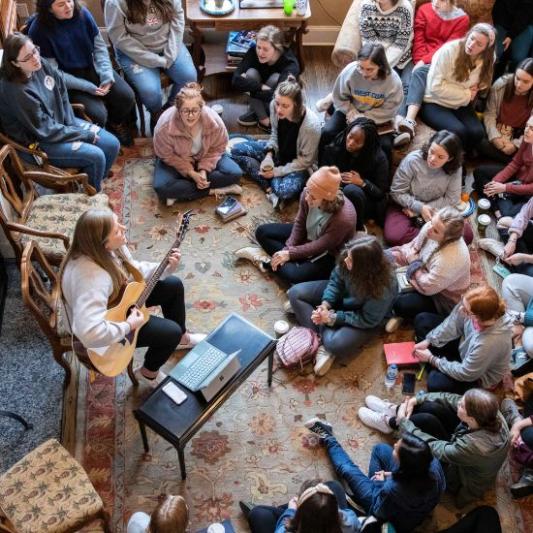 A room of women worshipping at women's retreat