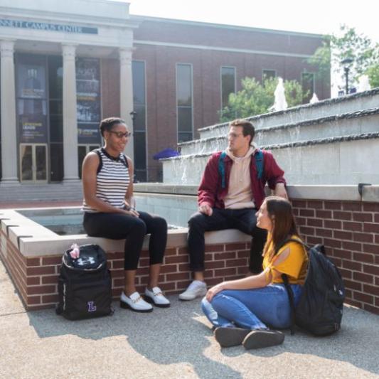 three students bonding on campus