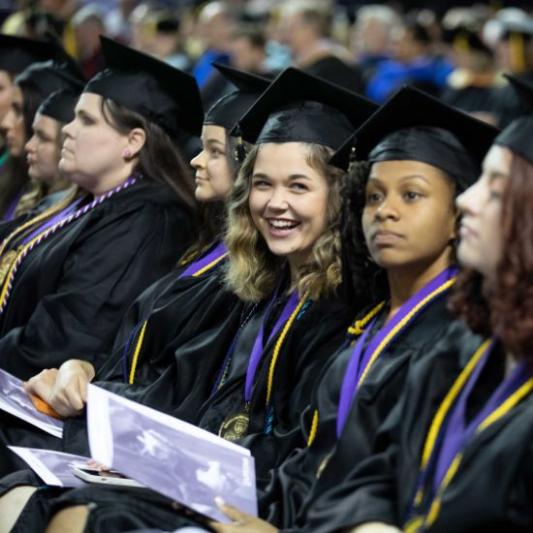 Five women smiling at undergraduate commencement