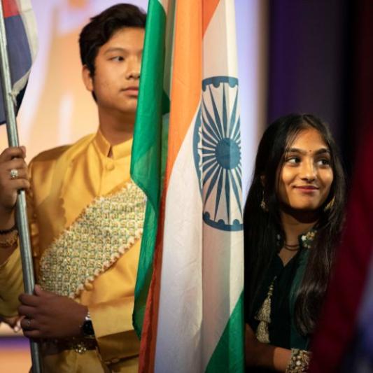 Two students holding international flags