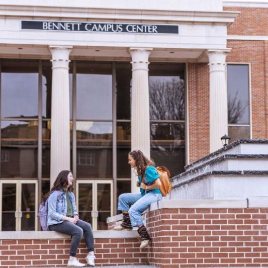 Two students talking on the steps in front of the campus center