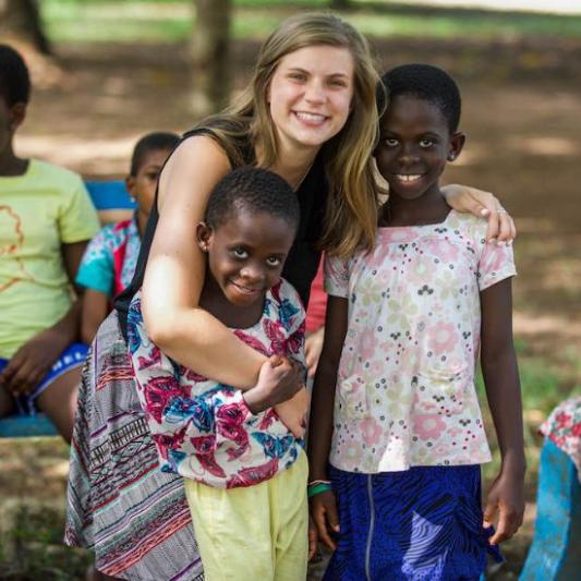 A Lipscomb student holding children in Ghana