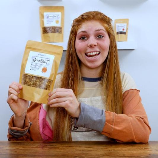 Student holding up granola as product demonstration