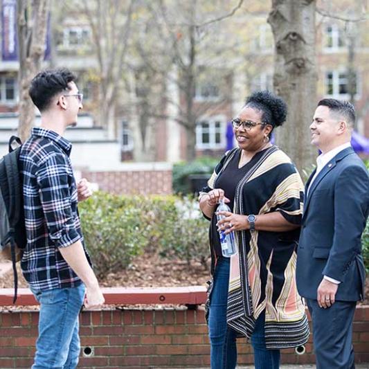 Three military-connected students talking outside