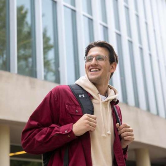 student smiling and wearing a backpack