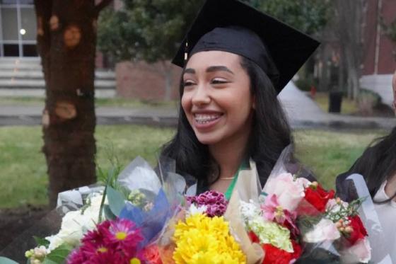 Verna Soliman in her cap and gown holding flowers
