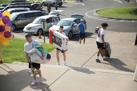 Parents carrying items into the dorms