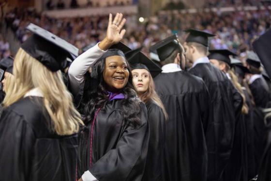 Undergraduate student waiving during commencement.